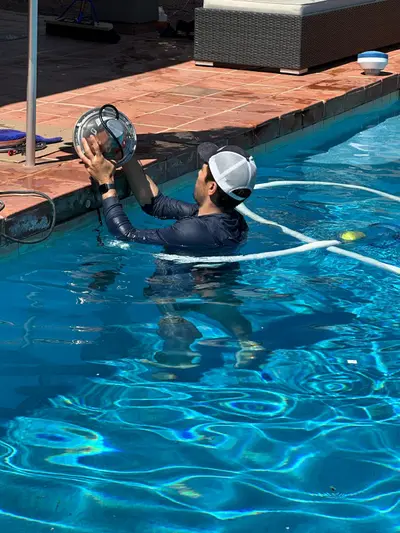 Pool technician replacing a pool light underwater